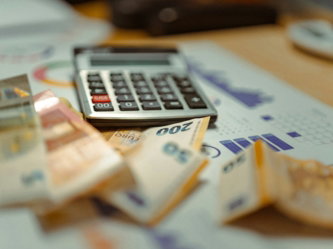 A calculator sitting on top of a pile of money